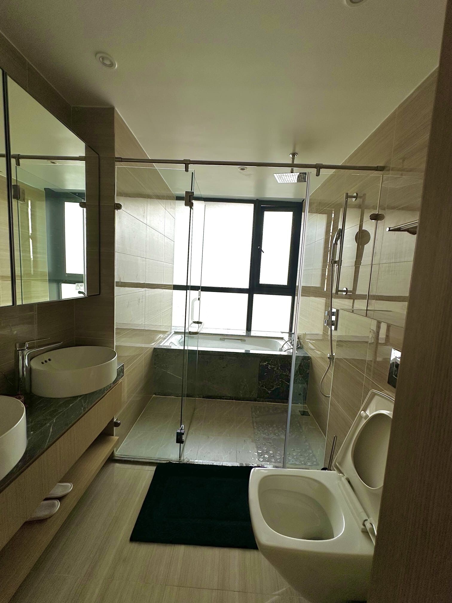 Un baño moderno con dos lavamanos, una bañera, una ducha e inodoro.