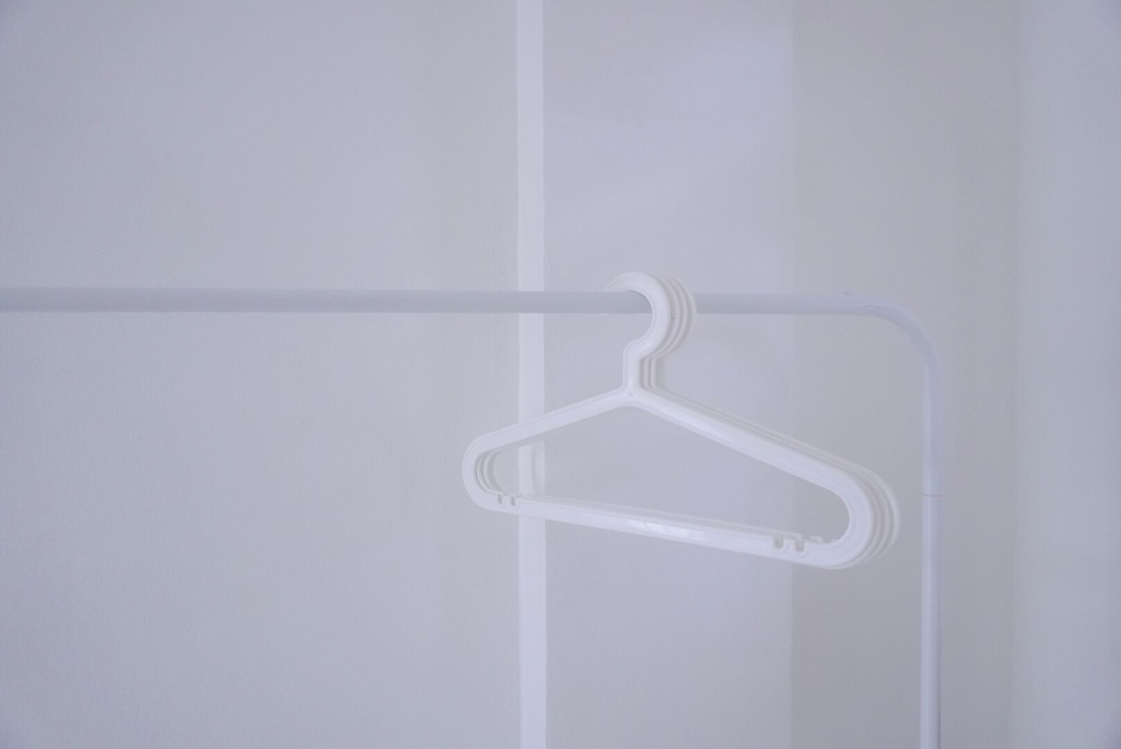 A white hanger on a white wall.