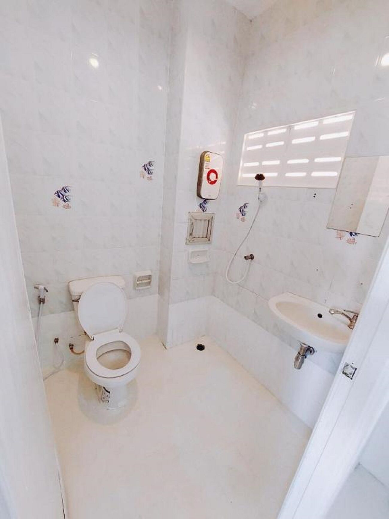 A small, modern bathroom with a toilet, sink, and shower.