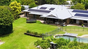A building with a flat roof, solar panels, a swimming pool, and a well-maintained lawn. - Hinterland Escape - Coastal Views, Pool & Fire Pit (Ninderry)