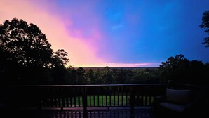 A deck with a railing and a grassy area in the background. - Escape to the peaceful, Cottage 3:12 at Suttle Ridge in Arkadelphia, AR (Arkadelphia)