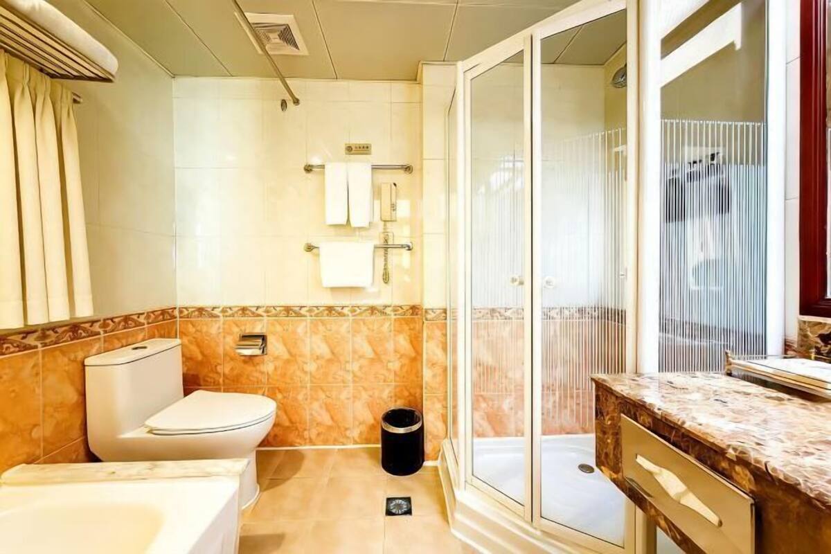 A bathroom with a toilet, sink, and shower area.