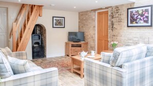 A living room with a fireplace, a television, and a sofa. - Stearn Cottage-17917 (Bury St. Edmunds)