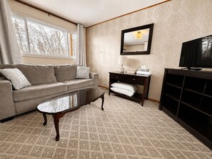 Suite, 1 queensize-seng, bassengutsikt | Oppholdsområde