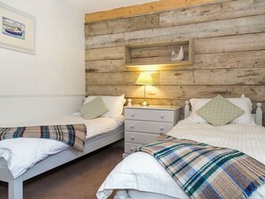 A room with two beds, a wooden headboard, a nightstand with a lamp, and a framed picture on the wall. - 2 bedroom accommodation in Marhamchurch, near Bude (Marhamchurch, near Bude)