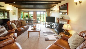 A cozy living room with leather sofas, a coffee table, a fireplace, and a television. - 3 bedroom accommodation in Stape, near Pickering (Stape, near Pickering)