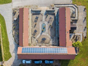 An aerial view of a building with a red roof, solar panels, and a central courtyard with seating. - 3 bedroom accommodation in Stape, near Pickering (Stape, near Pickering)