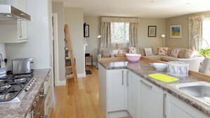 A modern kitchen with white cabinets, a granite countertop, and a gas stove. - 4 bedroom accommodation in Portpatrick (Portpatrick)