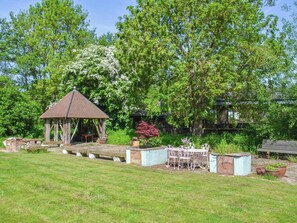 A gazebo with a tiled roof, surrounded by a grassy area and trees. - 4 bedroom accommodation in Hardham (Hardham)