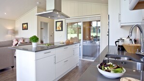 Une cuisine moderne dotée d’un îlot central, d’une cuisinière intégrée et d’une grande fenêtre.