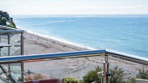 Ein Strand mit freiem Blick auf das Meer und einer Treppe, die zum Ufer führt.