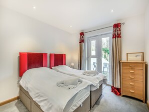 A hotel room with two beds, a wooden dresser, and a view of the outside. - 2 bedroom accommodation in Seaton (Seaton)