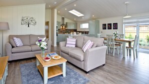 Un grand salon comprenant deux canapés, une table basse et une table à manger avec des chaises.