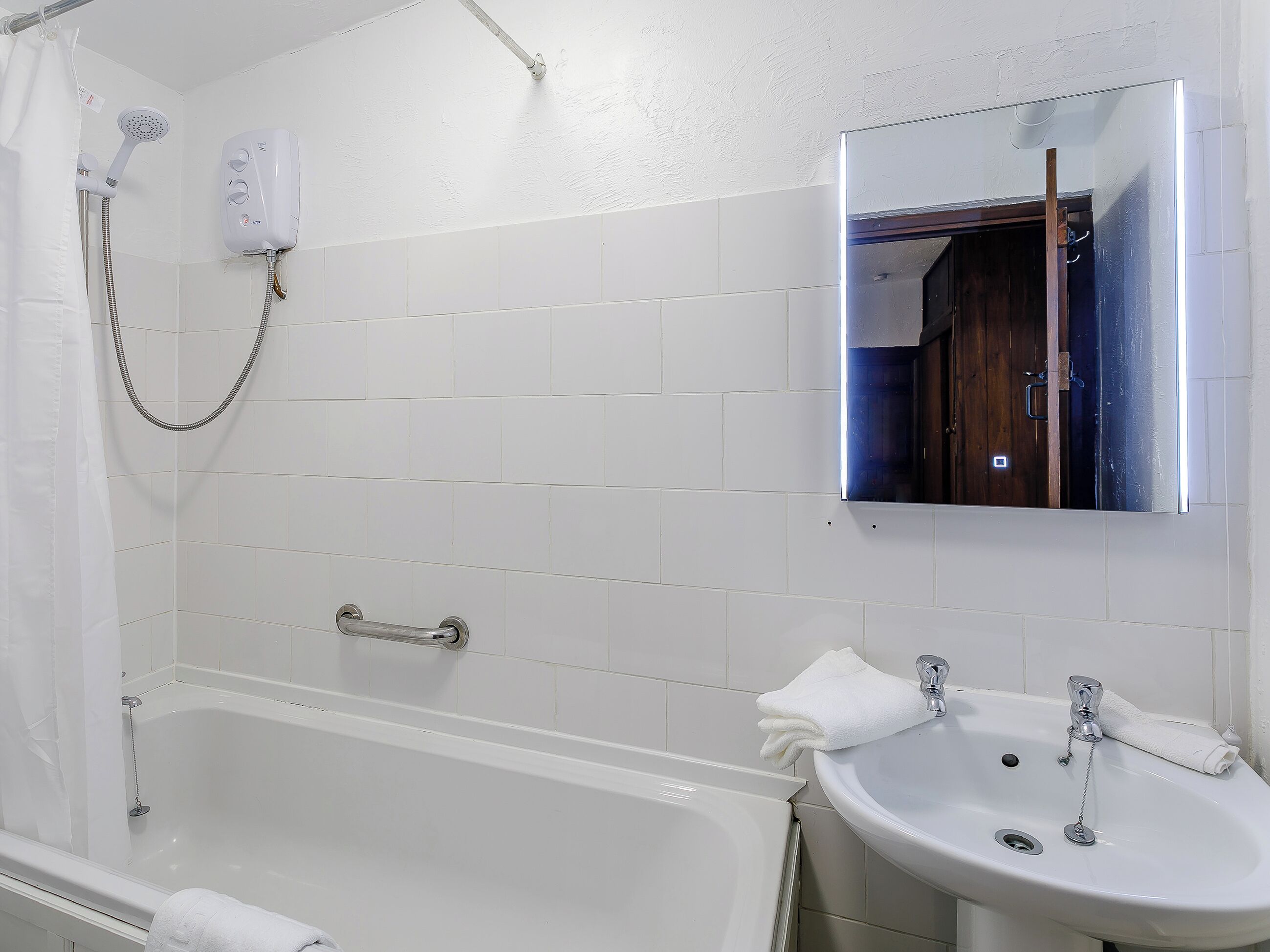 A bathroom with a bathtub, a sink, and a shower.