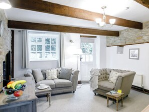 A cozy living room with two sofas, a wooden coffee table, and a fruit bowl.