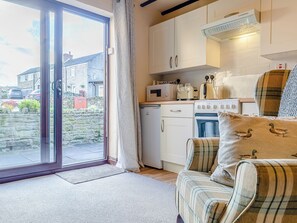 A kitchen with white cabinets, a microwave, a stove, and a window overlooking a street. - 4 lovely Cottages situated in the beautiful Derbyshire village of Barlow. (Barlow near Bakewell)
