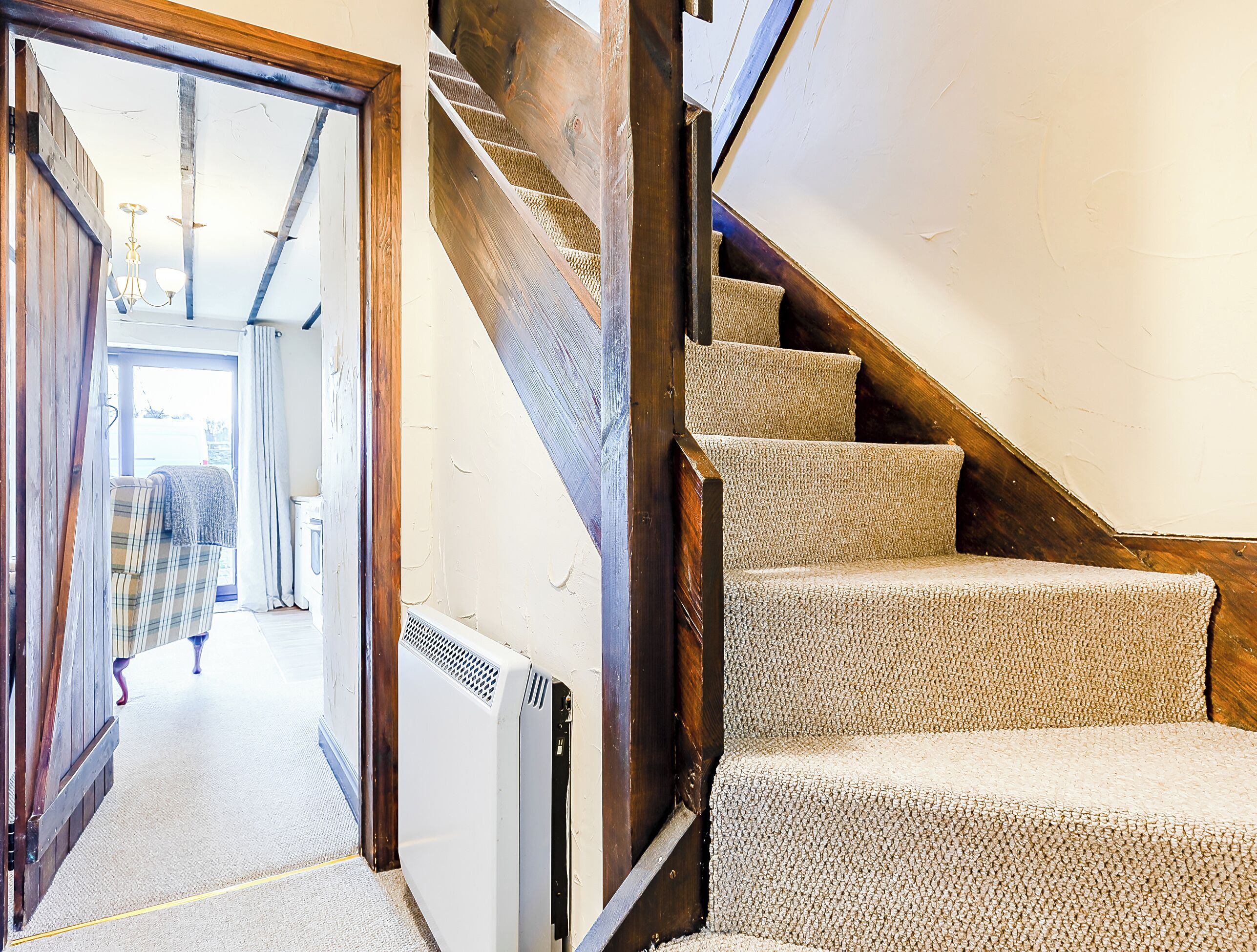 Un escalier avec des marches recouvertes de moquette et un radiateur fixé au mur.