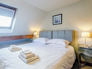 A neatly made bed with white linens and towels, a headboard, bedside lamps, and a framed picture on the wall. - Mill Farm Cottages - Kingfisher (Barlow near Bakewell)