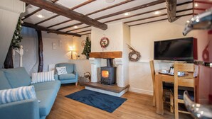 Ein gemütliches Wohnzimmer mit Kamin, Fernseher und Essbereich.