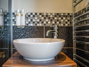 A bathroom with a white vessel sink, chrome faucet, and a checkered tile backsplash. - Gill Cottage - UK1277 (Castle Carrock, near Brampton)