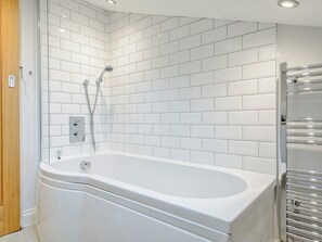 Un bagno moderno con piastrelle bianche tipo metro, una vasca freestanding e un box doccia in vetro.