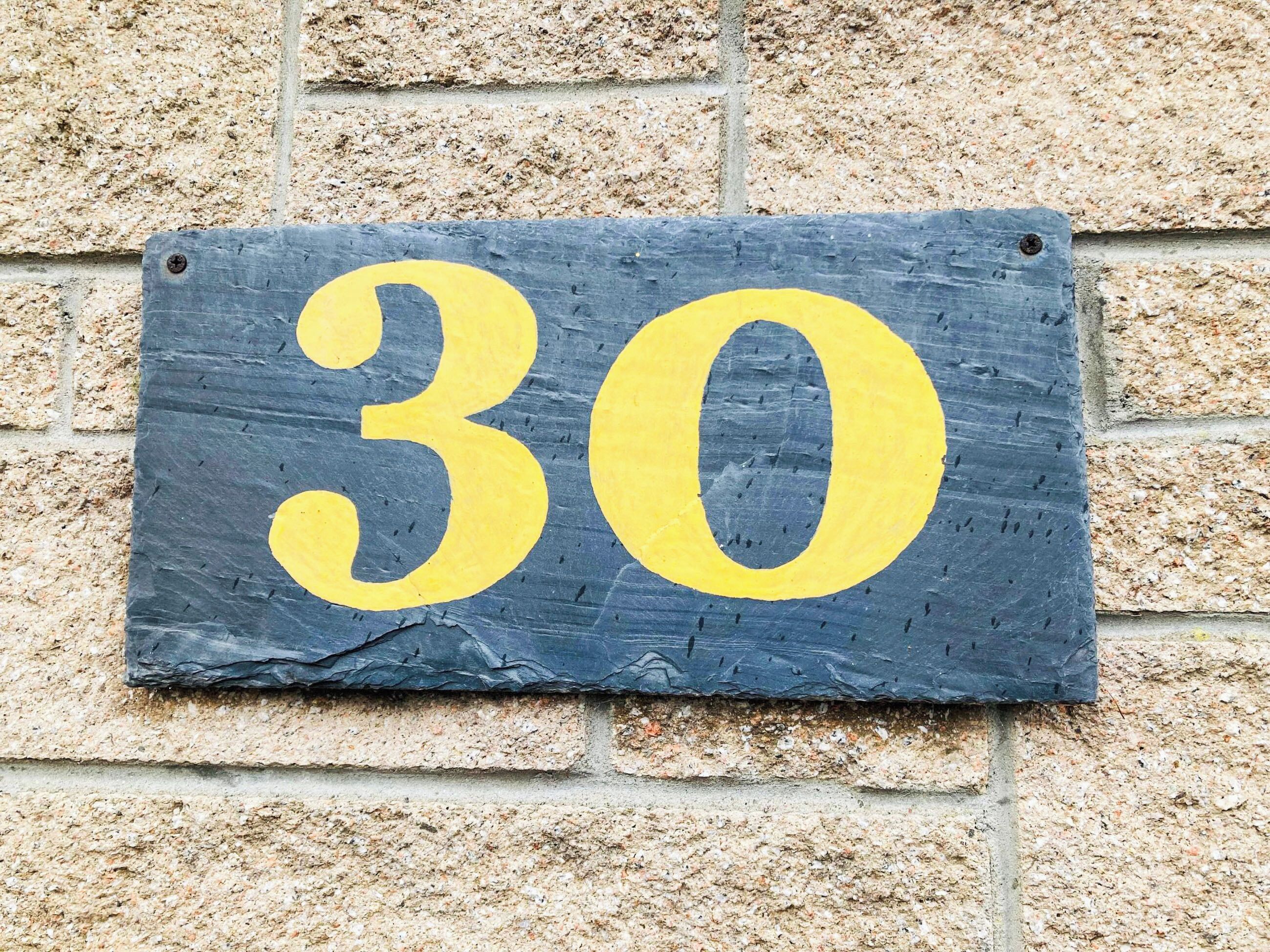 A house number sign with the number 30.