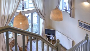 A staircase with a view of a living area, including a sofa and a television. - A charming two bedroom cottage, located in the village of Alston. (Alston)
