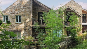 A stone building with a balcony and a window. - A charming two bedroom cottage, located in the village of Alston. (Alston)