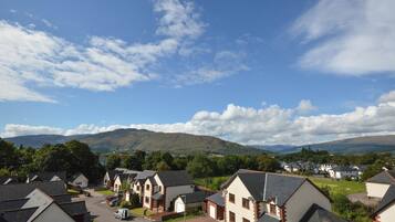 A residential area with houses, a clear sky, and distant mountains.