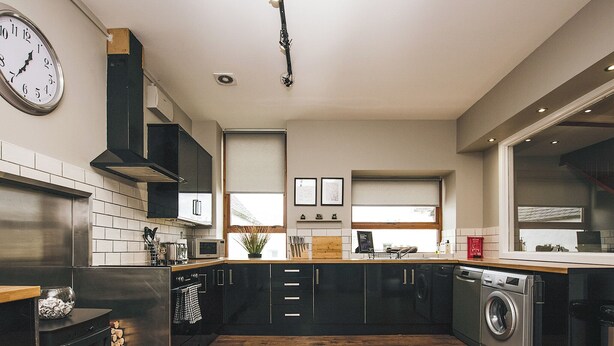 Una cucina moderna con isola centrale, elettrodomestici in acciaio inossidabile e pavimento in legno.