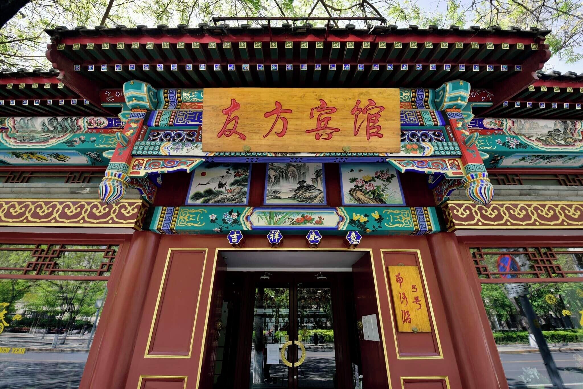 A traditional Chinese gate with intricate designs and a signboard.