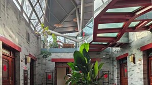 A spacious lobby with high ceilings, large windows, and potted plants. - Youfang Hotel - Beijing Tian'anmen Wangfujing Store (Beijing)