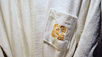 Una toalla blanca con un logotipo dorado bordado.