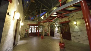 A spacious indoor area with high ceilings, exposed brick walls, and a mezzanine level. - Youfang Hotel - Beijing Tian'anmen Wangfujing Store (Beijing)