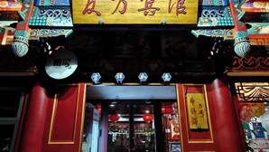A traditional Chinese building with a large yellow sign, red doors, and intricate architectural details. - Youfang Hotel - Beijing Tian'anmen Wangfujing Store (Beijing)