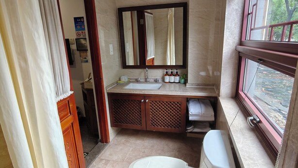 A bathroom with a toilet, sink, and mirror. - Youfang Hotel - Beijing Tian'anmen Wangfujing Store (Beijing)