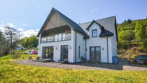 A two-story house with a modern design, featuring a large front porch and a garage. - 4 bedroom accommodation in Gairlochy, near Spean Bridge (Gairlochy, near Spean Bridge)