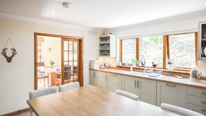 A modern kitchen with a wooden countertop, a built-in sink, and a window providing natural light. - 4 bedroom accommodation in Gairlochy, near Spean Bridge (Gairlochy, near Spean Bridge)