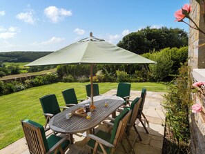 A patio with a table, chairs, and an umbrella. - Thirley Cotes Farmhouse (Harwood Dale, near Scarborough)