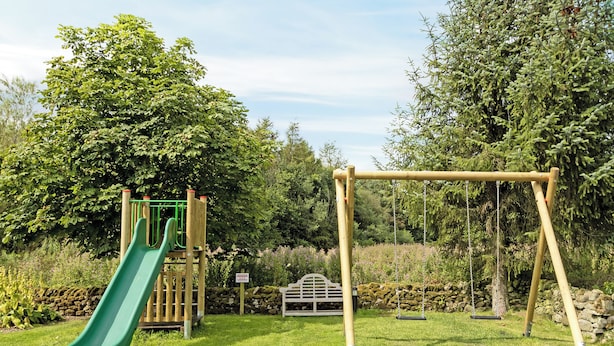 Een speeltuin met een glijbaan en schommels.