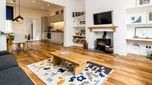 Uma sala de estar moderna com sofá, mesa de centro, lareira, televisão e estantes.