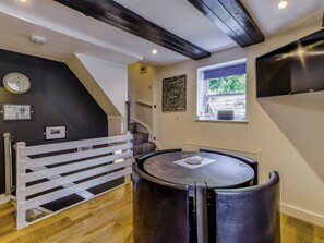A room with a round table, a white bench, a window with a view, and a black ceiling. - 2 bedroom accommodation in Whitby (Whitby)