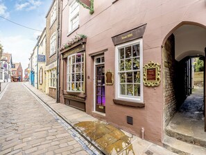 A historic street with cobblestone pavement, a shop with a 'Handmade Bath Products' sign, and a 'Since 2005' plaque. - A historical cottage, tucked away in the heart of Whitby’s old town. (Whitby)