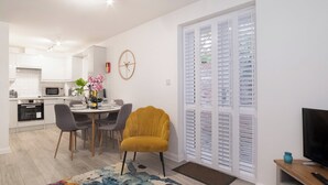 En moderne lejlighed med spiseplads, køkken og opholdstue.