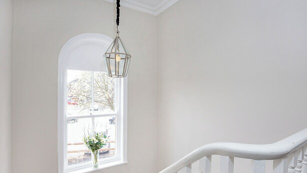 A staircase with white railings and a hanging light fixture. - George Street Two - UK2767 (York)