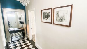A hallway with a checkered floor, a chandelier, and two framed pictures on the wall. - George Street One - UK2766 (York)