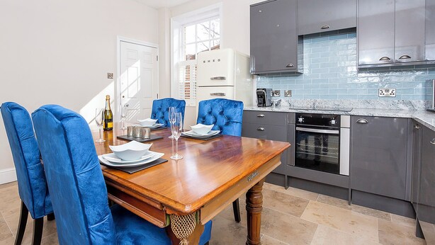 A modern kitchen with grey cabinets, a marble countertop, and a built-in oven. - George Street One - UK2766 (York)