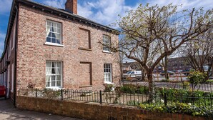 A two-story brick building with a traditional design, featuring a large window on the ground floor and a smaller window on the upper floor. - George Street One - UK2766 (York)