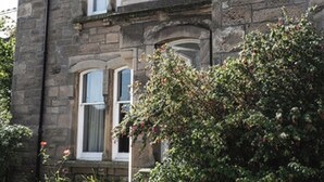 A stone building with multiple windows and a balcony. - This stunning Victorian property has just finished a full renovation. (Elgin)