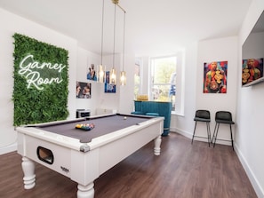 A pool table in a room with a neon sign reading "Game Room," a green wall, and a window with a view. - 5 bedroom accommodation in York (York)